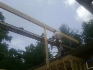 Carpenter setting a ridge beam over a new addition frame — Ice Dam Removal by Roofing Brothers in Shields