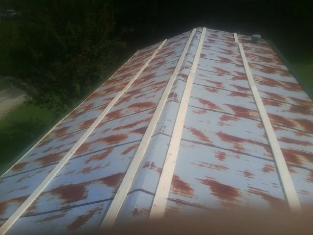 Rusted metal roof panels with new wood purlins before replacement — Storm Damage Roof Repair in Shields by Roofing Brothers