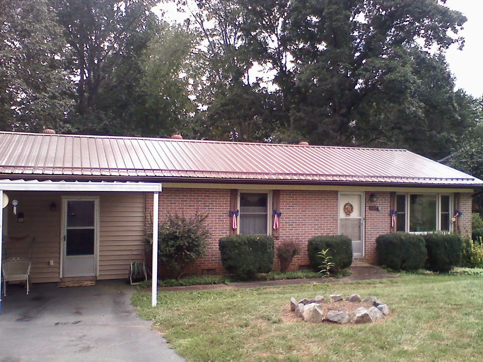 Bronze metal roof and carport on a brick ranch home — Roof Repair work by our crew in Shields